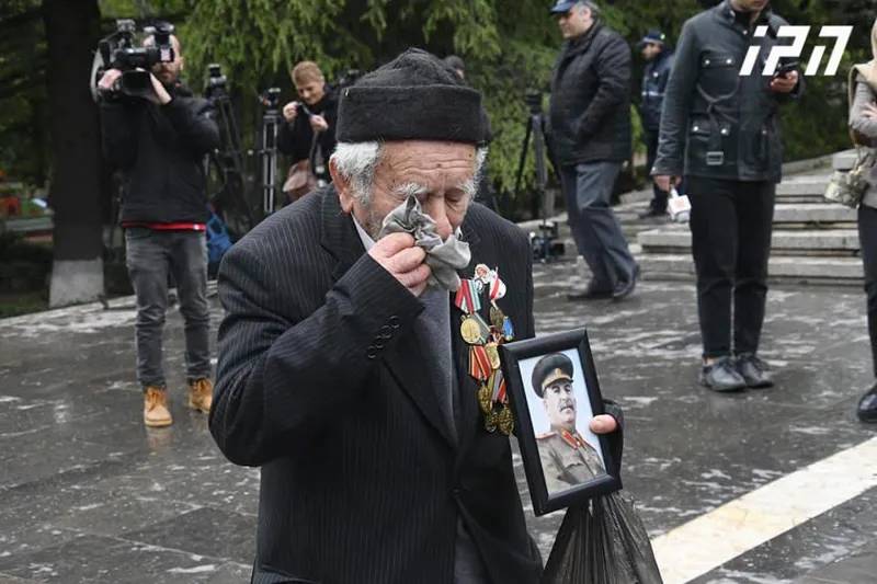 Фото из парка Ваке: плачущий ветеран с фотографией Сталина в руках и цветы, возложенные к могиле Неизвестного солдата